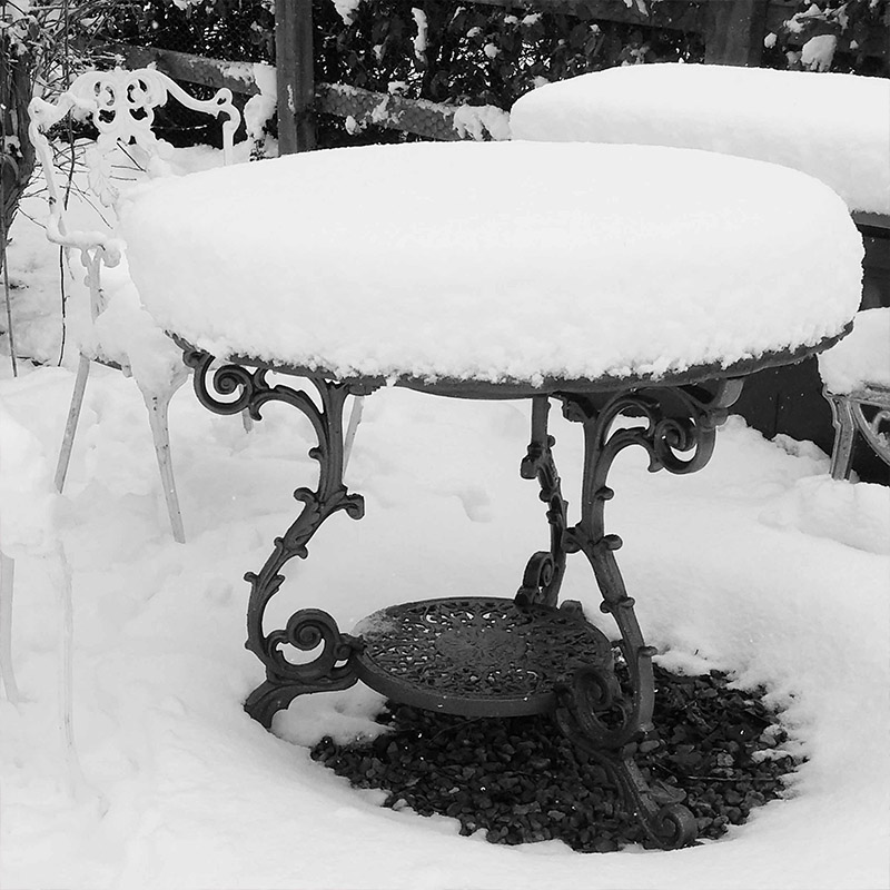 Snow covered iron garden table